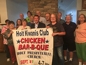 Holt Kiwanis members displaying a chicken Bar-b-que sign